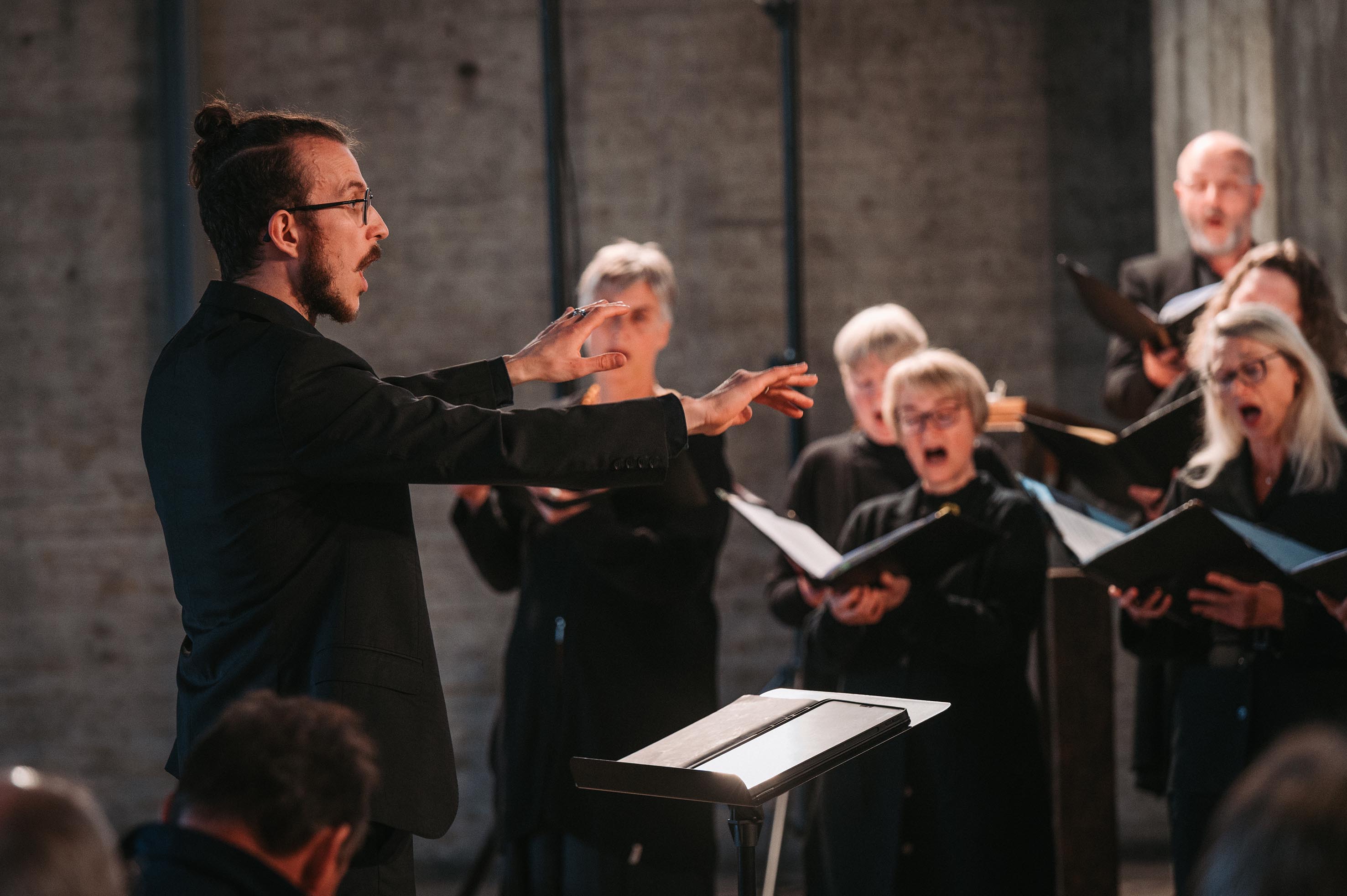 Moritz dirigiert und SängerInnen singen im Hintergrund